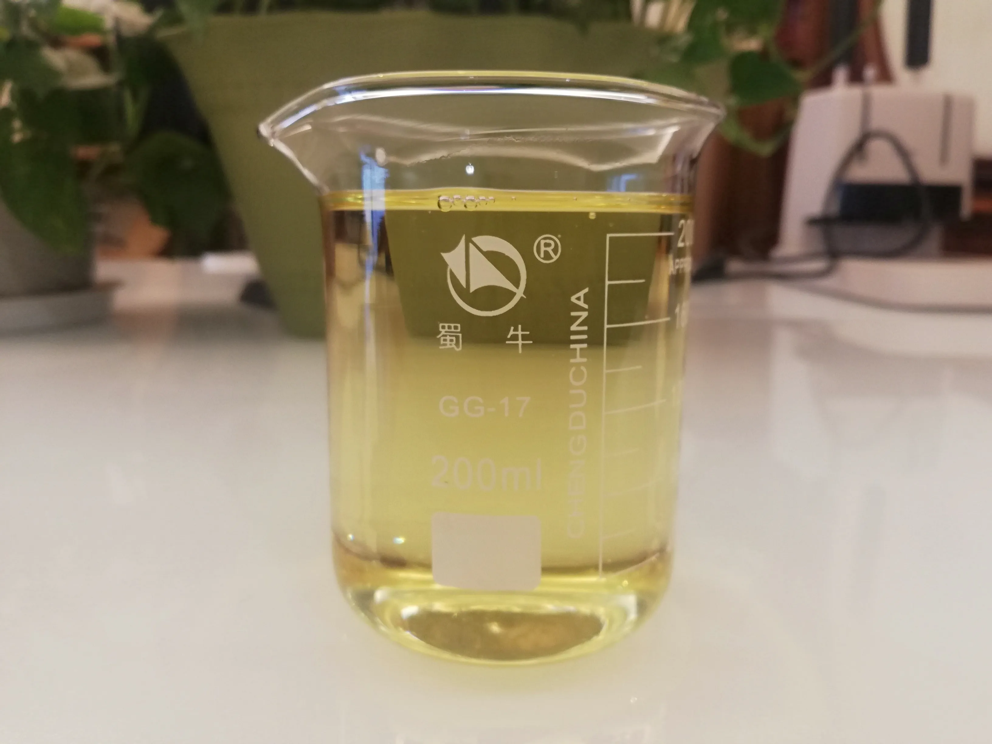 HX-YZJ01 pce-based precast concrete admixture sample in 200ml laboratory beaker showing light yellow liquid